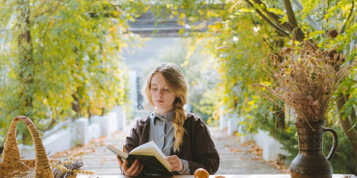 A tween lost in thought while reading a book, reflecting on emotions and relationships.