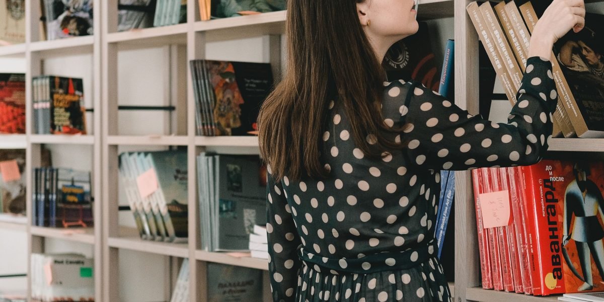 A person contemplating a selection of books, feeling overwhelmed by choices.