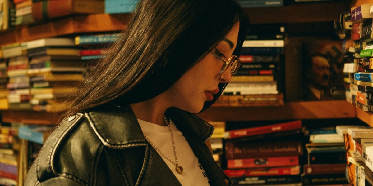 A person thoughtfully browsing a bookshelf or digital library, embodying the challenge of discovering new books amidst overwhelming choices.