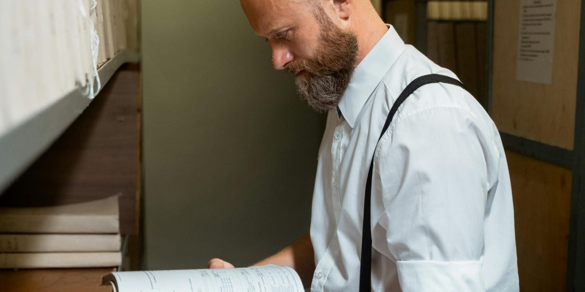 A person carefully inspecting an old book, emphasizing the need for diligence when buying used books online to ensure quality and authenticity.