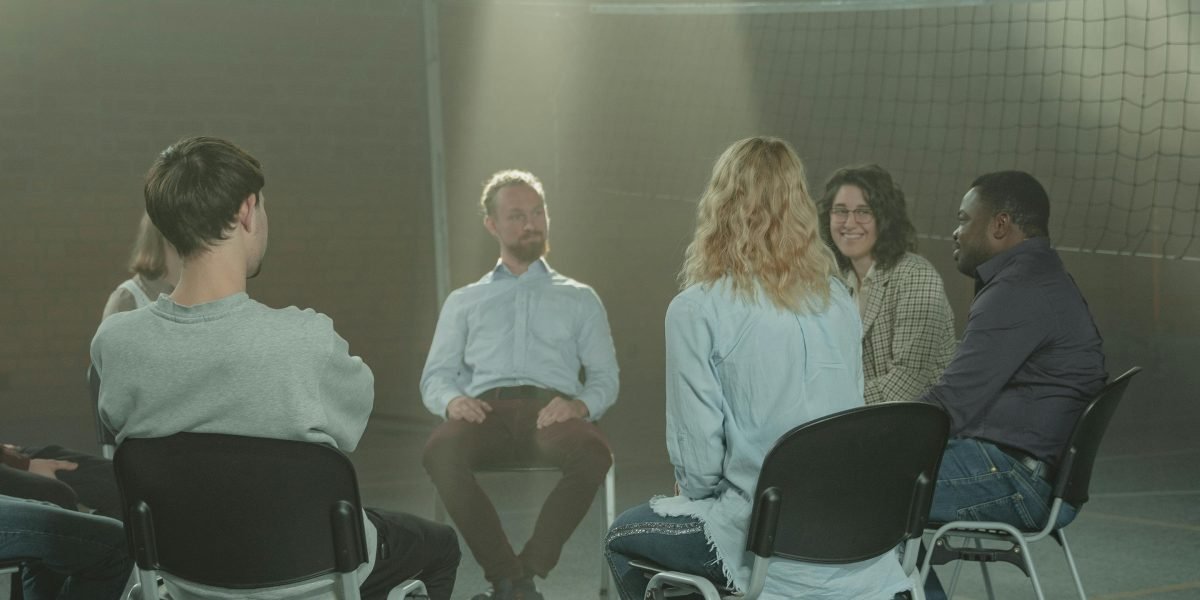 A small group of individuals in an isolated environment, looking at each other with suspicion, reflecting psychological tension.