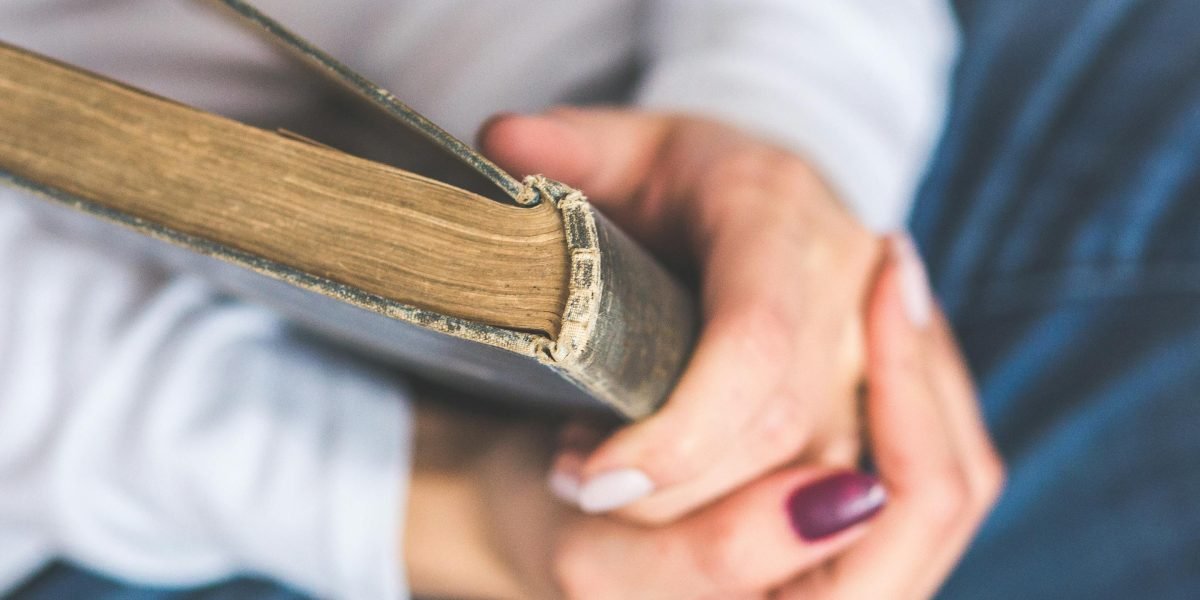 A person immersed in reading an antique book, highlighting the historical context of classic literature.